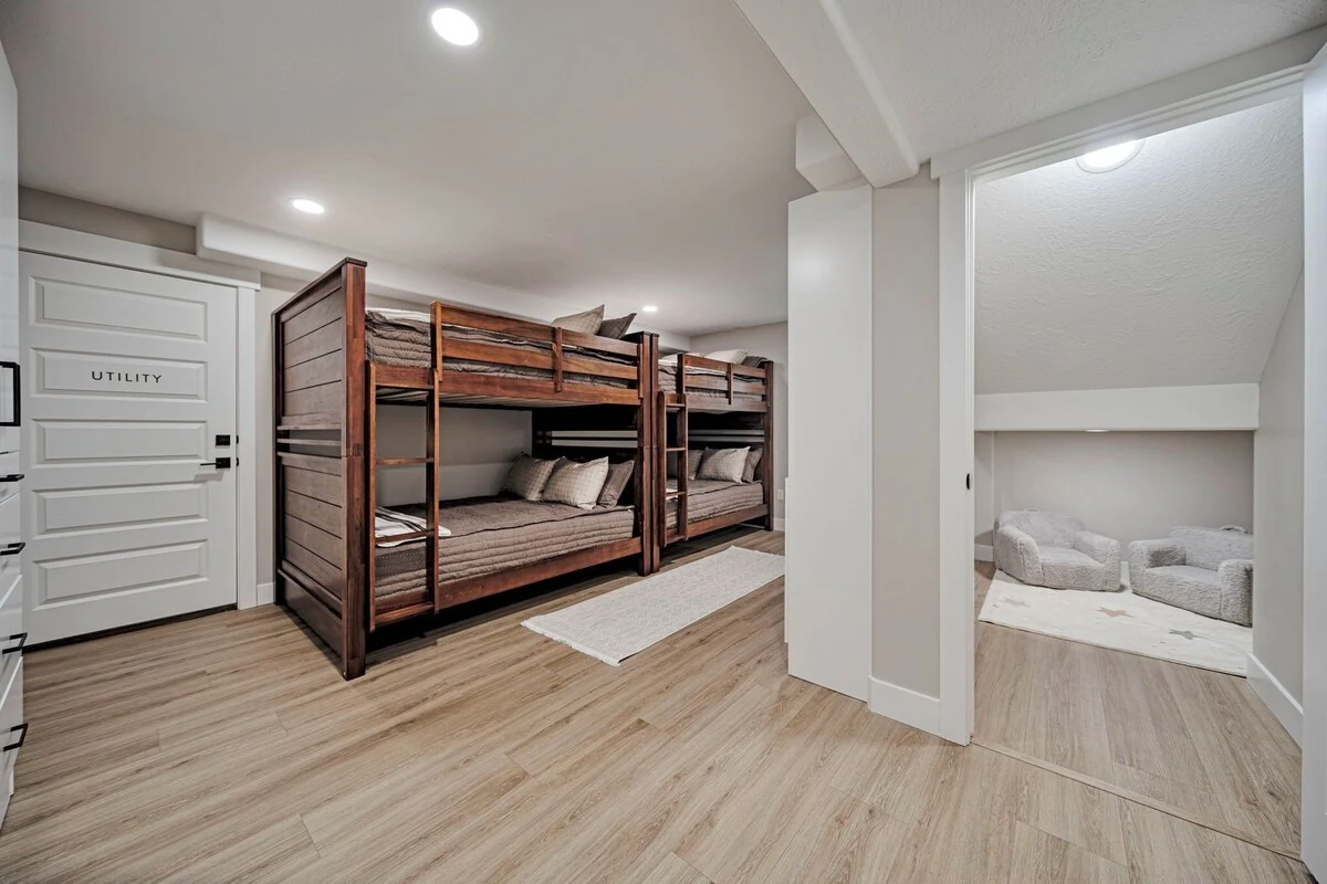 Basement bunk bedroom with two wood-framed bunk beds and four full-size mattresses
